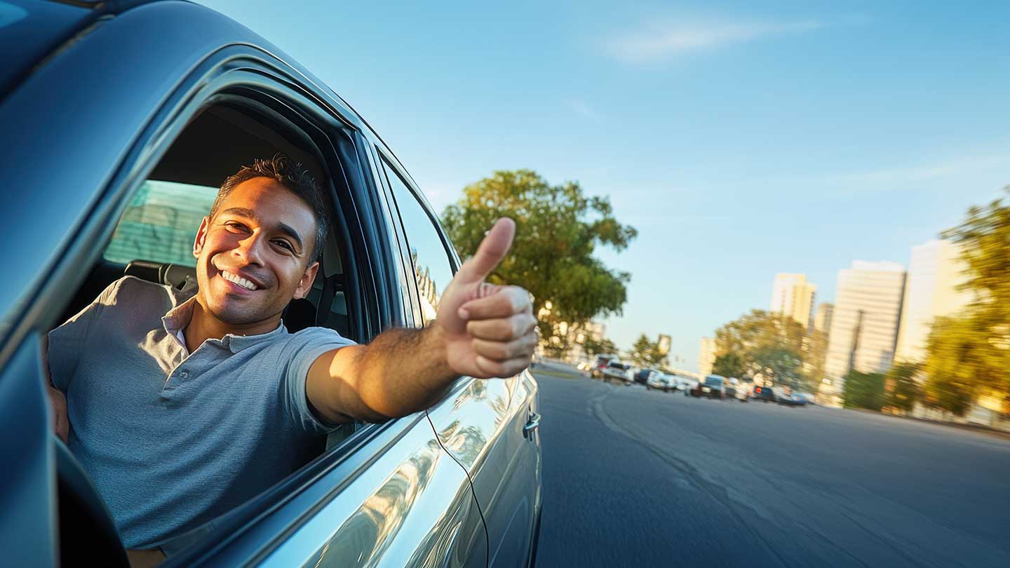 Man giving thumbs-up out of his car window