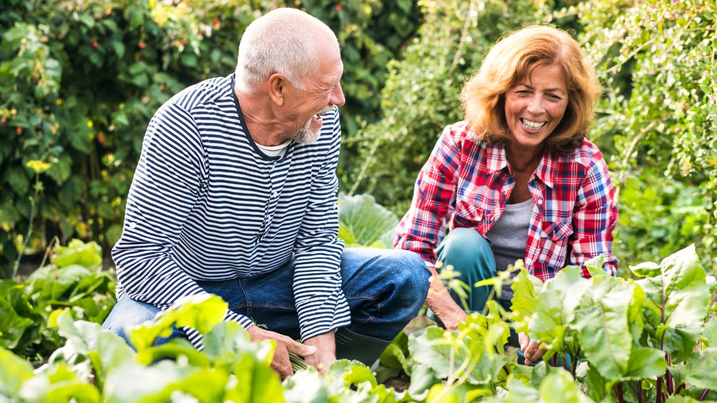 Couple gardening and woman holding watering can