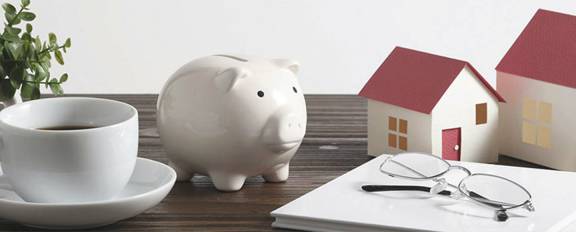 Piggy bank, coffee cup and model home